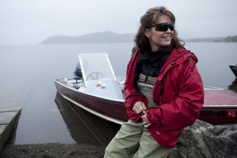 DILLINGHAM, ALASKA -JULY 02 2010: Sarah Palin ready to head up the river in Todd's boat to go see the fish counting (where a Fish & Game official regulates the fishing open and closed hours by counting the fish coming up the river)  in Dillingham, where Todd salmon fishes every year in July, and where the Palin family usually spend 4th of July.